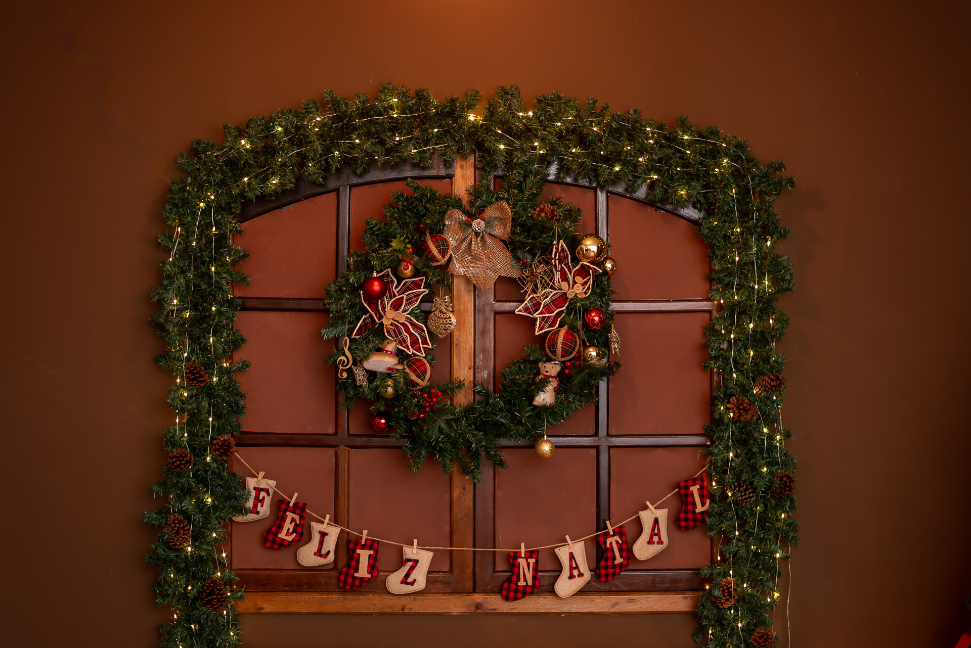 Janela decorada com guirlanda natalina e a inscrição Feliz Natal