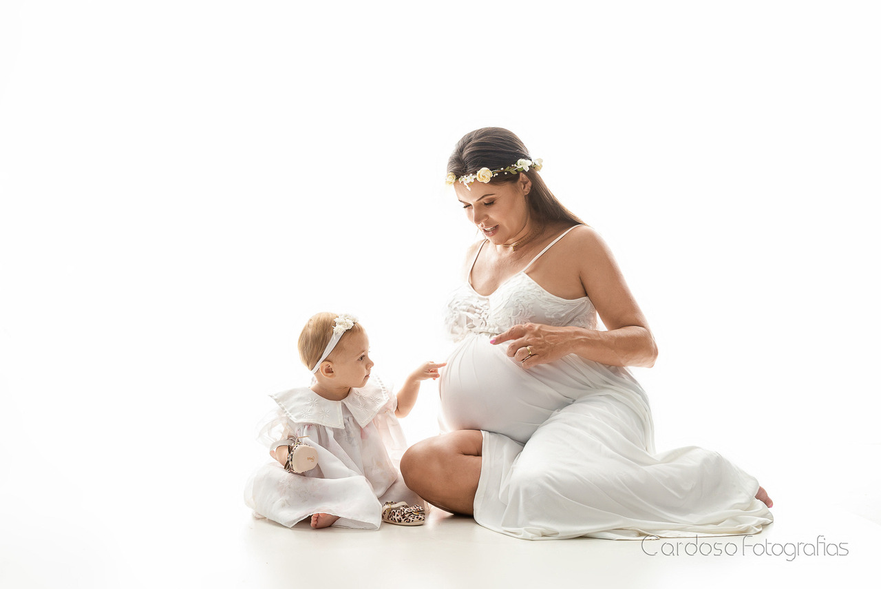 gestante com filha durante ensaio fotográfico em estúdio em Indaial