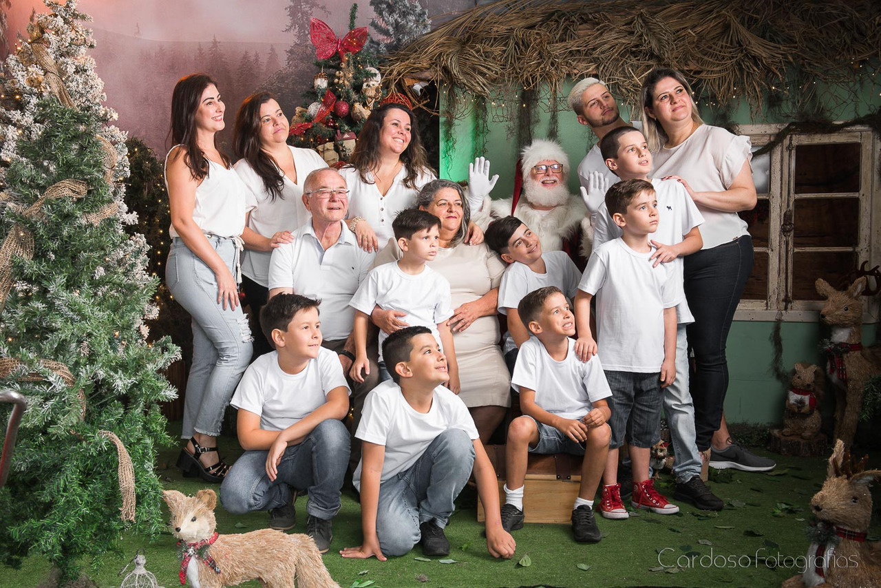 14 pessoas posando no ensaio de Natal no Cardoso Fotografias, vieram de Blumenau para fotografar a família toda: avós, tios, pais, netos e o Papai Noel de verdade. Uma fotografia para guardar para sempre a magia da família reunida