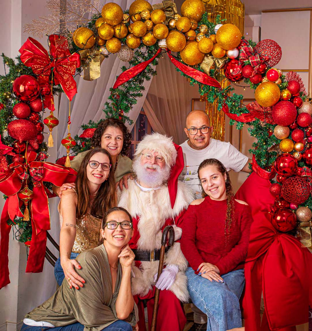 Toda a esquipe do cardoso Fotografias e o Papai Noel de verdade durante o ensaio de 2025 no cenário com o tema de "Brilho do Natal"