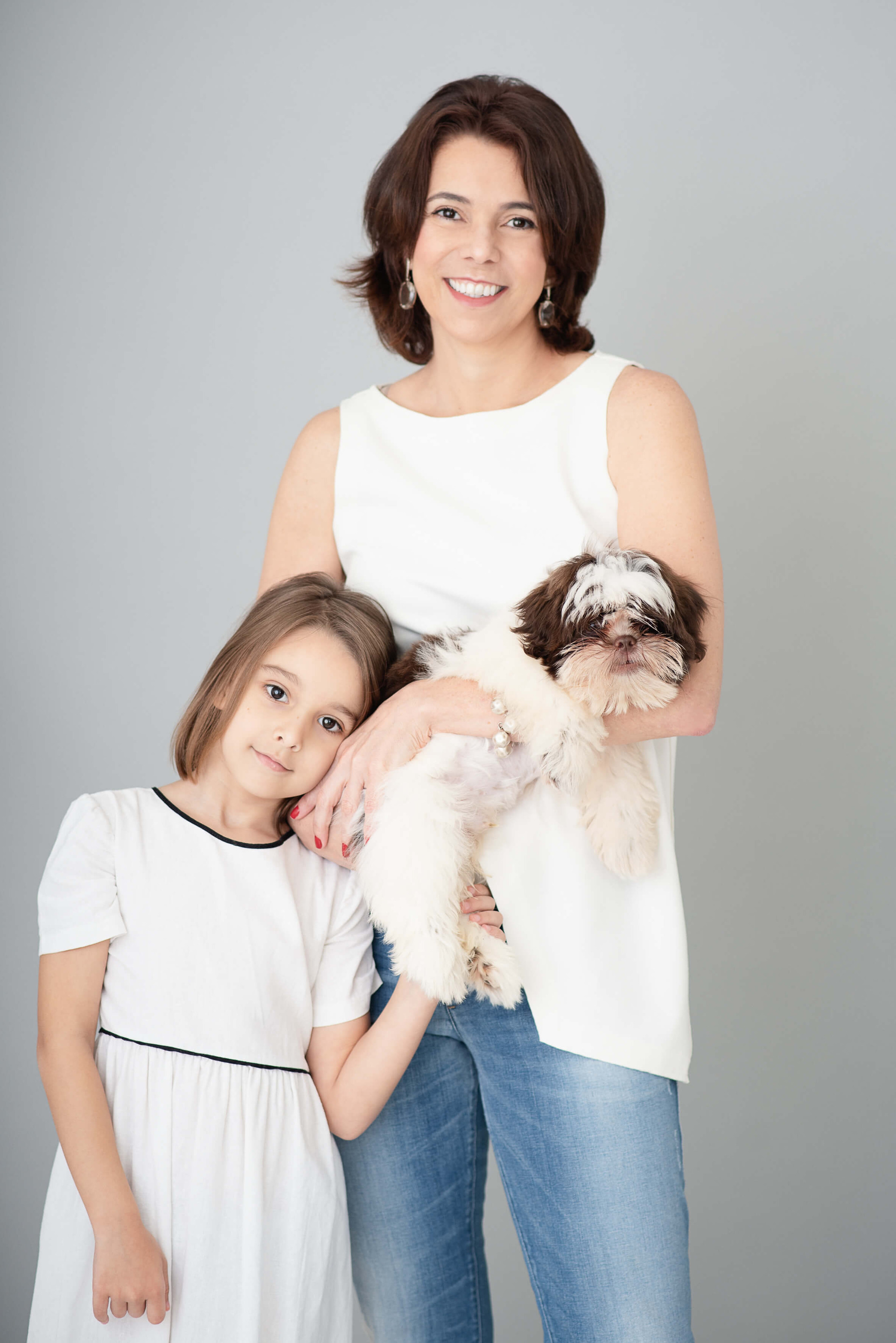 Retrato em estúdio de tia, sobrinha e cachorro, em clima de afeto e conexão familiar