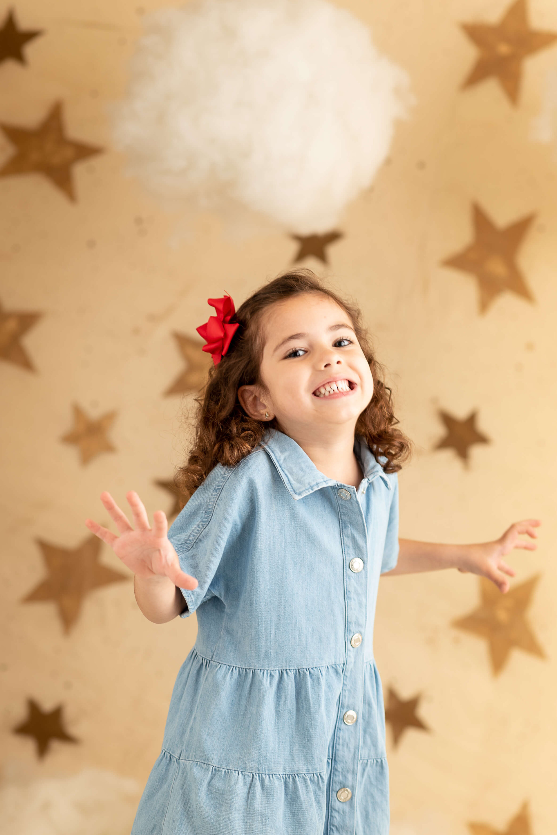 criança de vestido laranja com fundo de estrelas