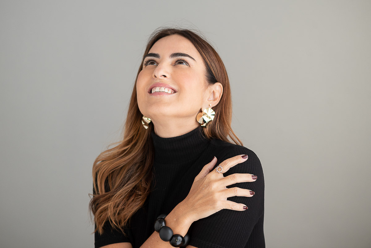 Headshot de mulher sorrindo em fundo neutro, ideal para LinkedIn e site profissional