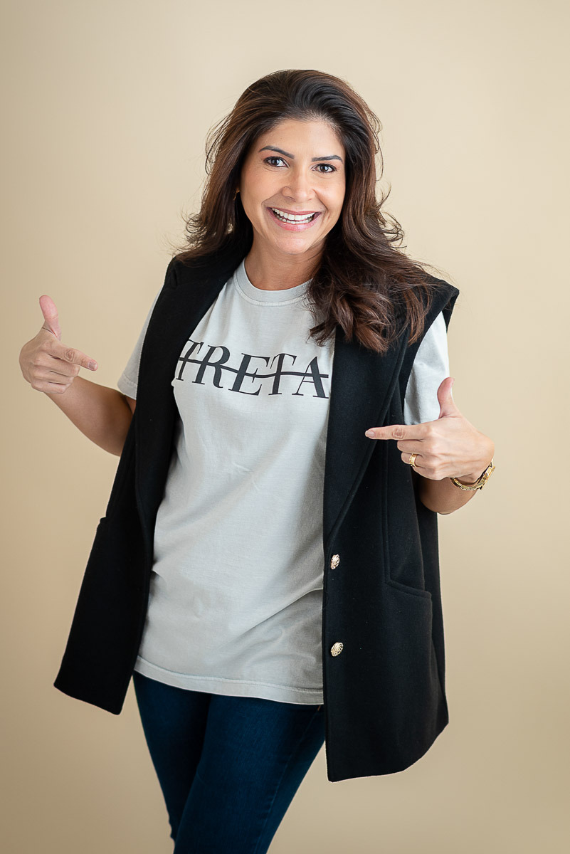 Empreendedora sorrindo com camiseta e colete preto, retrato moderno e descontraído feito no estúdio Dani Justus no Rio