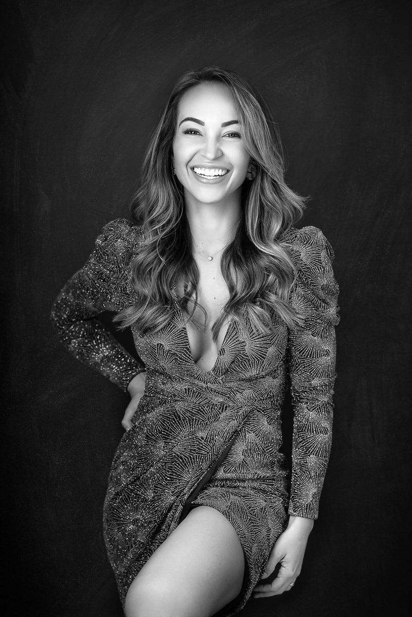 Mulher sorridente em retrato feminino espontâneo, com postura confiante e expressão de alegria. Ensaio fotográfico de autoestima.