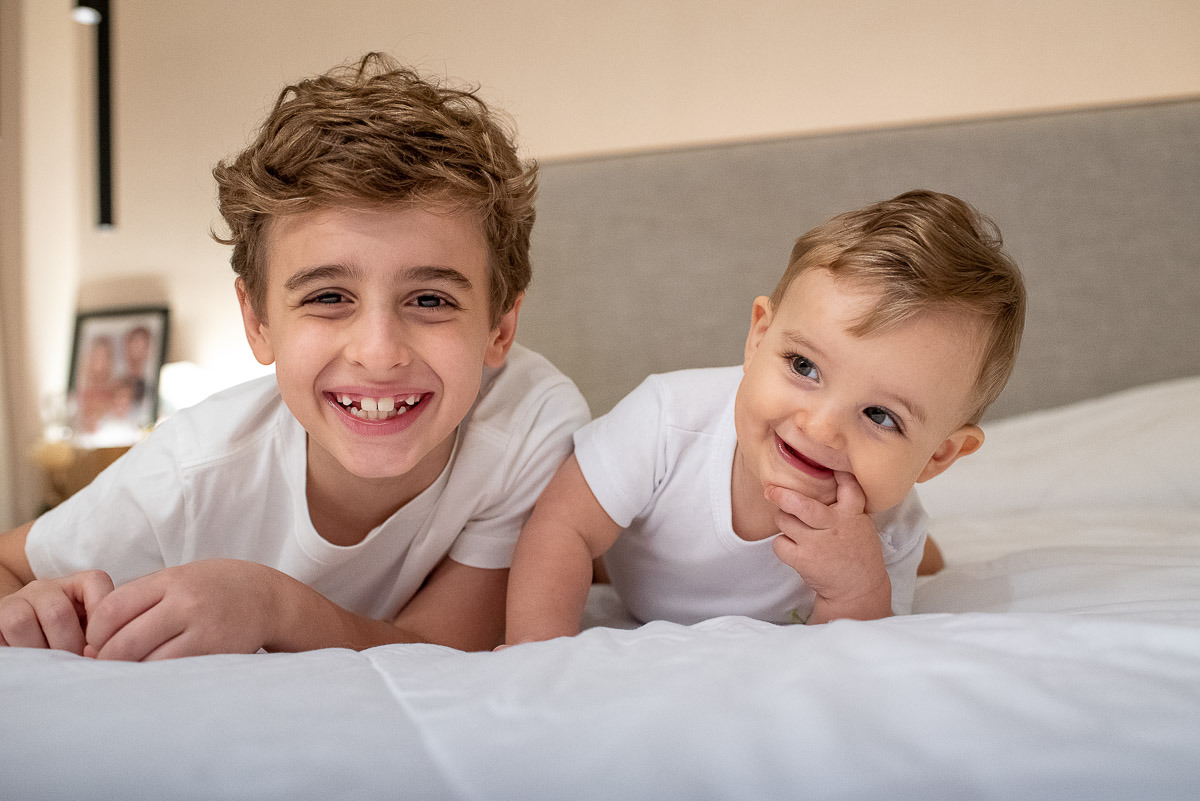 Irmãos na cama dos pais em ensaio fotográfico em casa