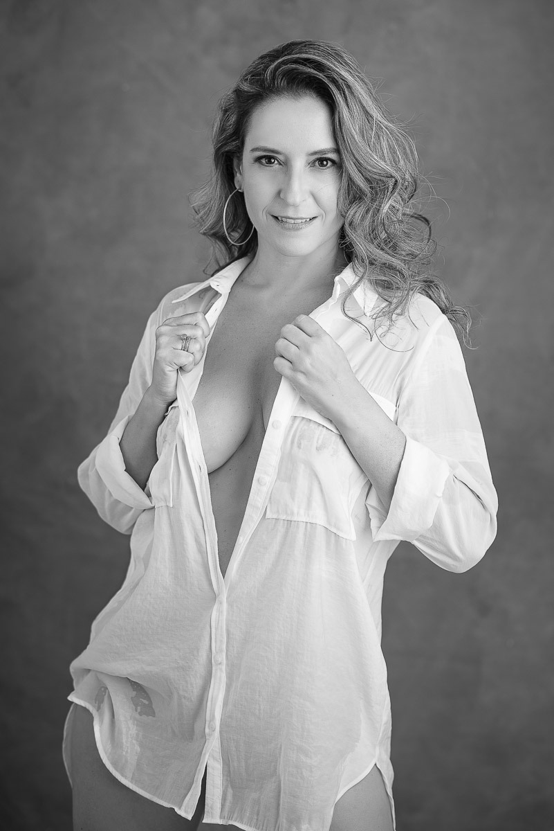 Mulher sorridente em retrato feminino espontâneo, com postura confiante e expressão de alegria. Ensaio fotográfico de autoestima.