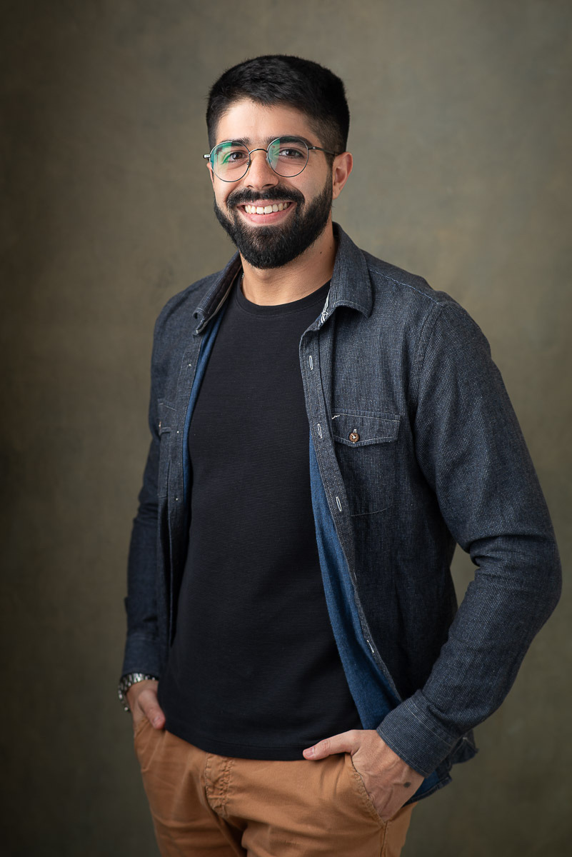 Retrato de médico sorrindo em ensaio de estúdio, com óculos e jaqueta, fundo neutro — estúdio Dani Justus, Jardim Botânico, Rio de Janeiro