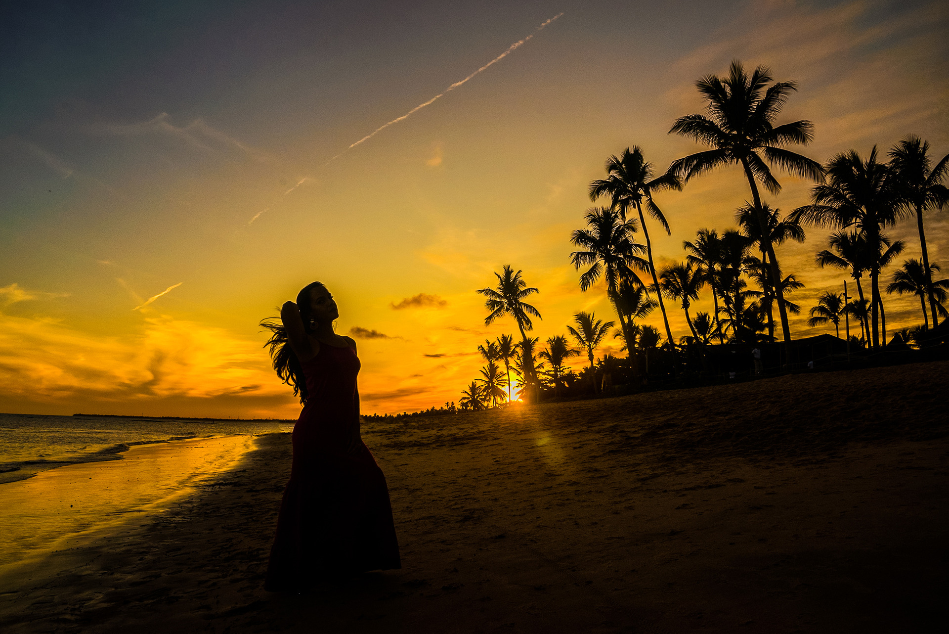 Mulher em um ensaio fotográfico no por do sol de praia do forte