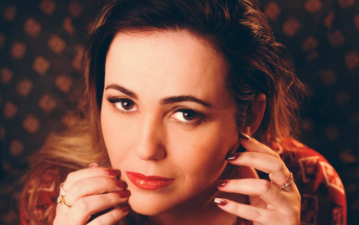 Mulher com olhar confiante e luz quente de estúdio em retrato feminino profissional — Duo Capuano Fotografia