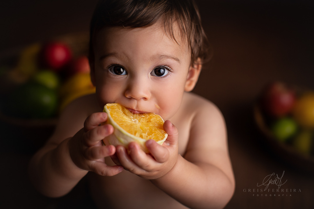 ensaio de bebe com fruta laranja