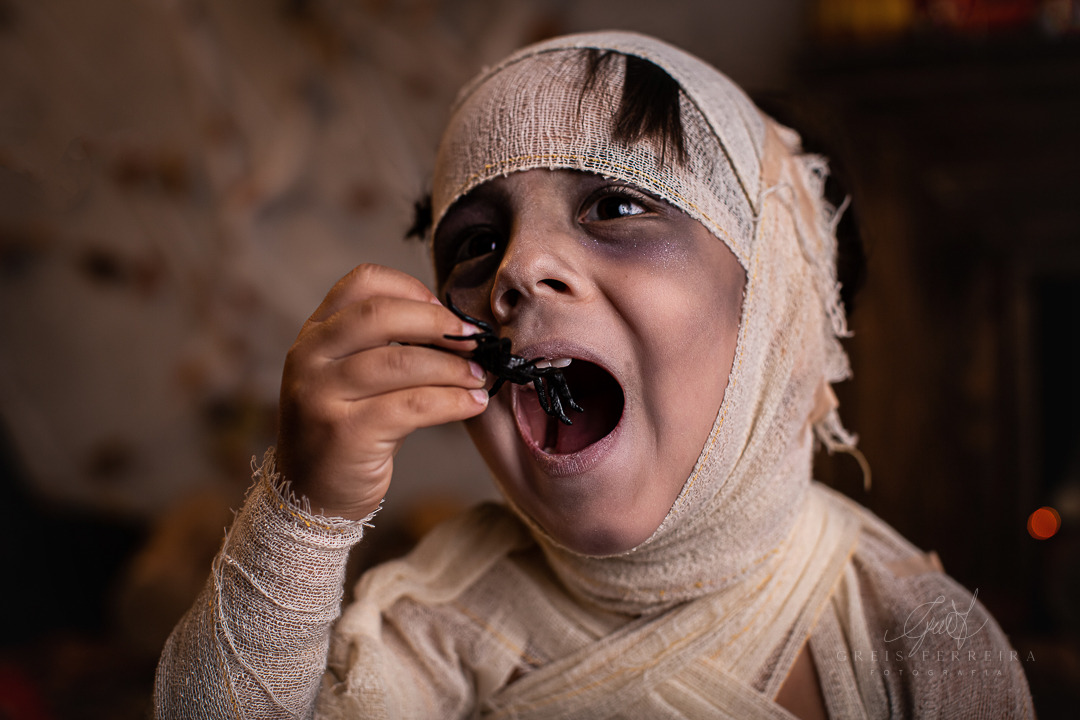 ensaio infantil de halloween mumia comendo aranha