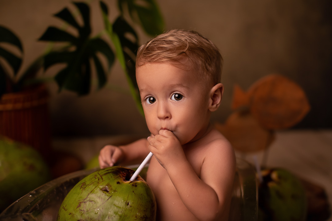 Foto de bebê provando tomando água de côco