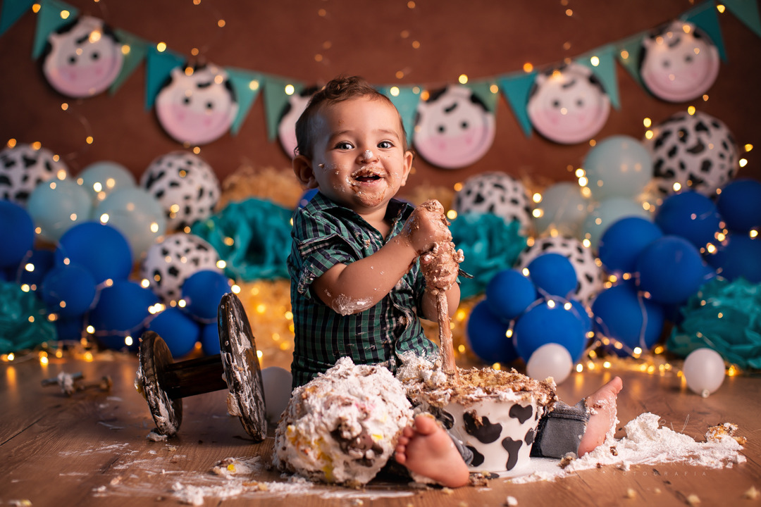 smash the cake ensaio bebe sorrindo depois de comer bolo