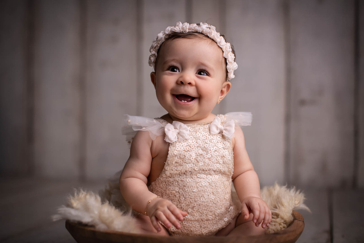 ensaio de bebe menina sentado em uma gamela com pelo