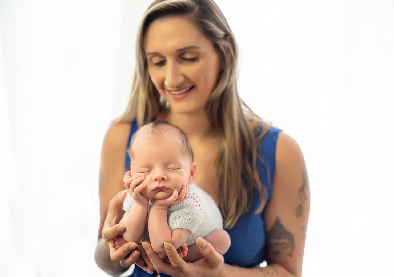 Mãe segurando seu bebê foto de recem nascido , recém-nascido na coisa do sapinho fotografada pela habilidosa fotógrafo gaúcha Aline Fontes