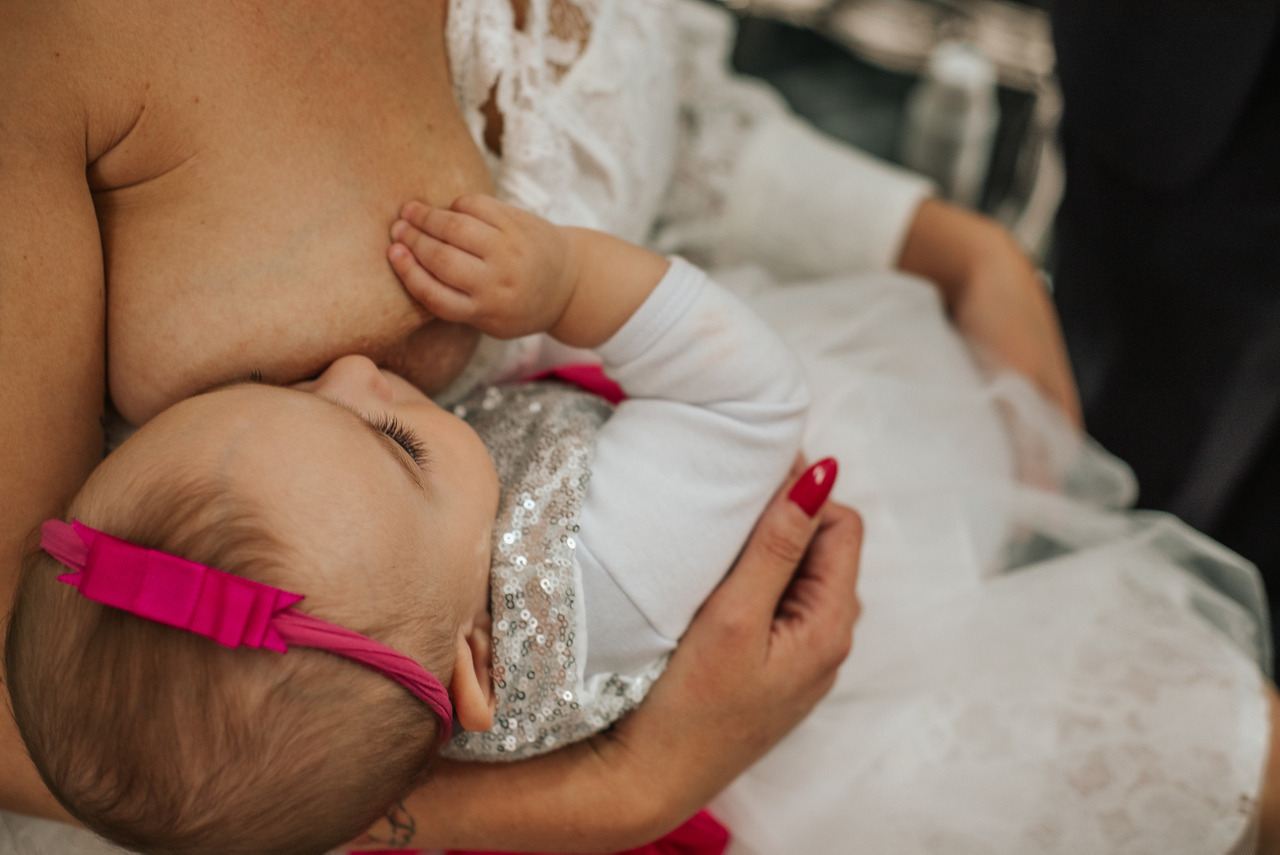 Amamentação no dia do casamento sendo fotografada pela Aline Fontes a mãe e o recém-nascido