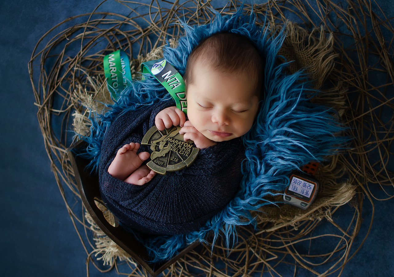 bebê em ensaio newborn com medalha de supermaratona fotografado pela fotógrafa Aline Fontes em Bento Gonçalves