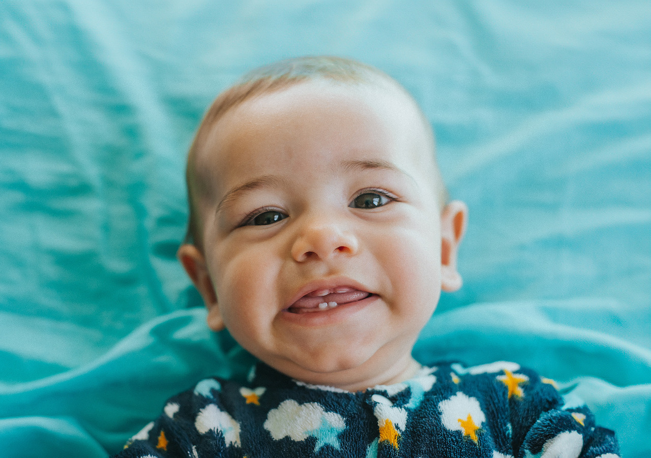 bebê sorrindo mostrando os primeiros dentinhos