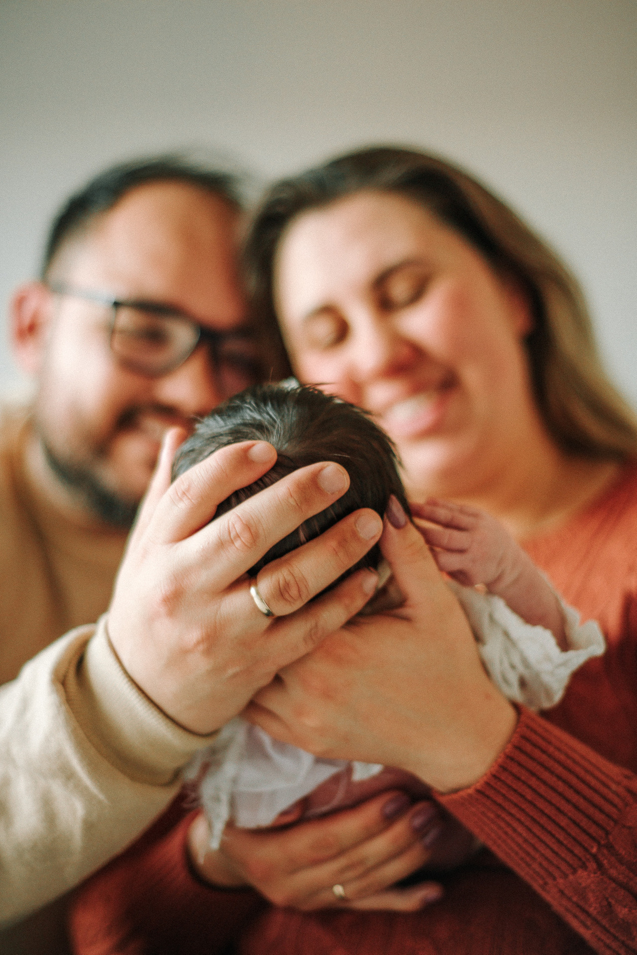 Fotografia newborn lifestyle de pais segurando bebê recém-nascido no colo, em imagem sobre ECA Digital, portfólio e uso consciente de fotos de bebês.