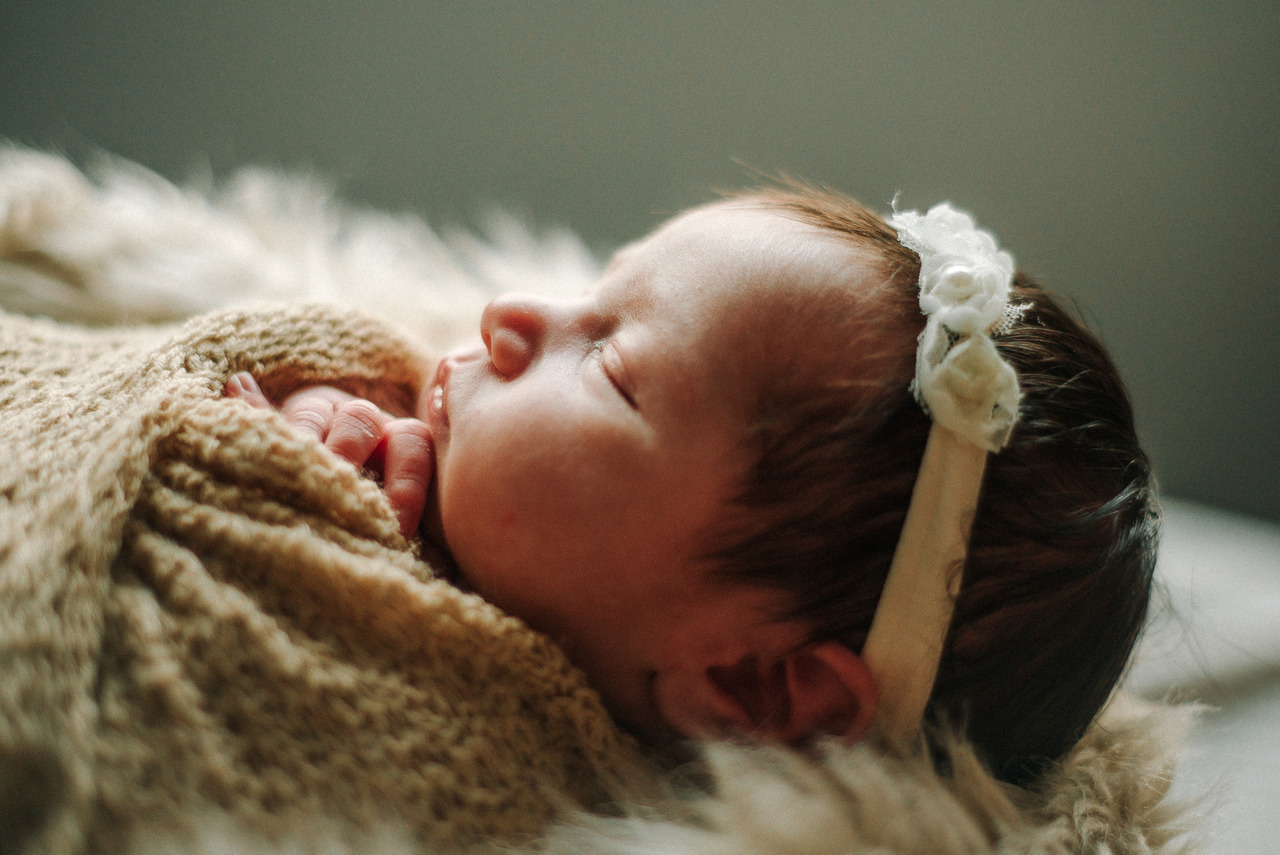 Bebê recém-nascida dormindo em ensaio newborn tradicional, com manta e acessório delicado, representando o cuidado com exposição infantil, portfólio newborn e ECA Digital.
