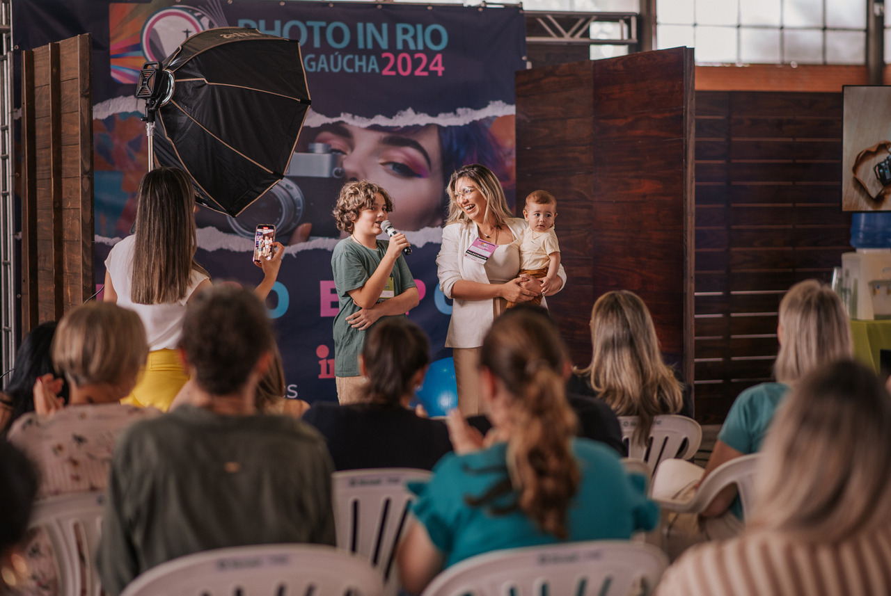 Aline Fontes palestrando sobre fotografia newborn e imagem infantil com seus filhos presentes, em artigo para mães sobre fotos dos filhos nas redes sociais e compartilhamento consciente.