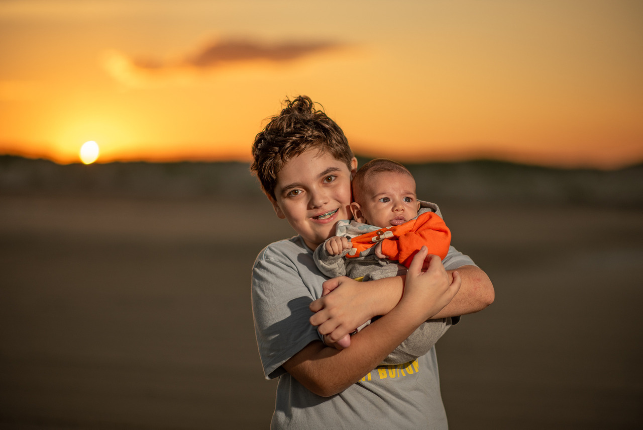 Filhos de Aline Fontes em foto ao pôr do sol na praia, em guia para mães sobre fotos dos filhos nas redes sociais, memória familiar e imagem infantil consciente.