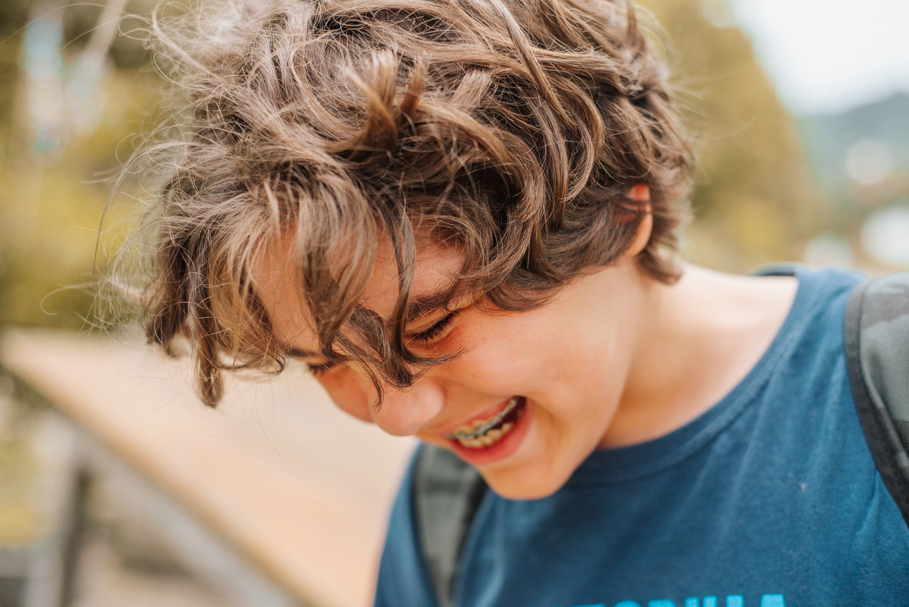 Menino sorrindo em um registro espontâneo ao ar livre, em imagem usada por Aline Fontes para falar sobre espontaneidade, infância e compartilhamento consciente de fotos dos filhos.
