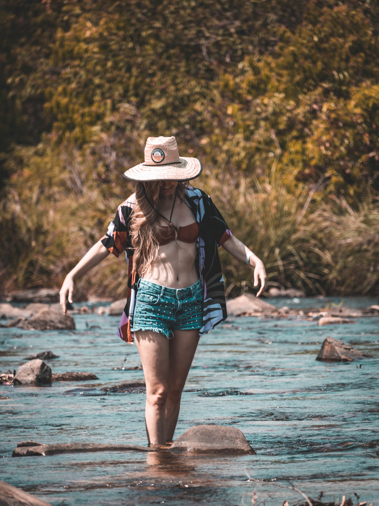 Mulher andando sobre as pedras em cachoeira em Goiás