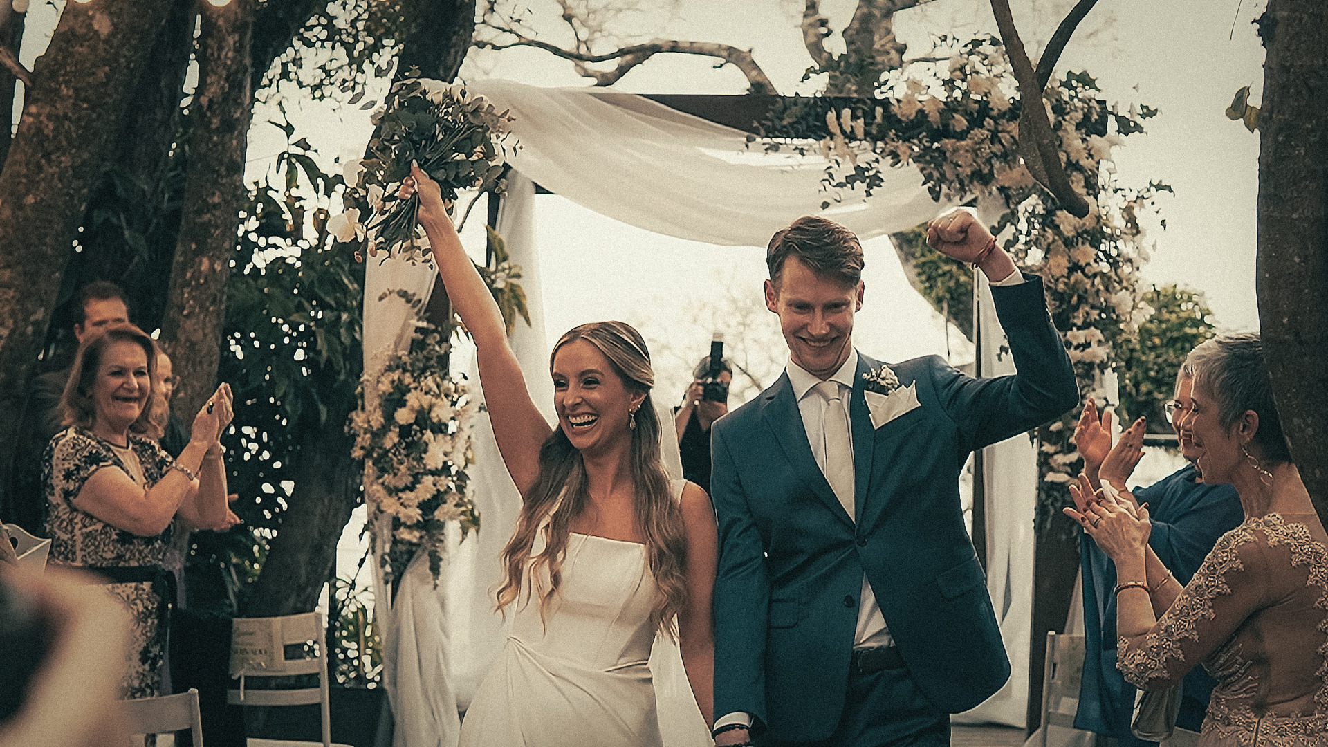 Casal de noivos felizes celebrando sua união em filmagem de casamento em Porto Alegre rodeados por amigos e família