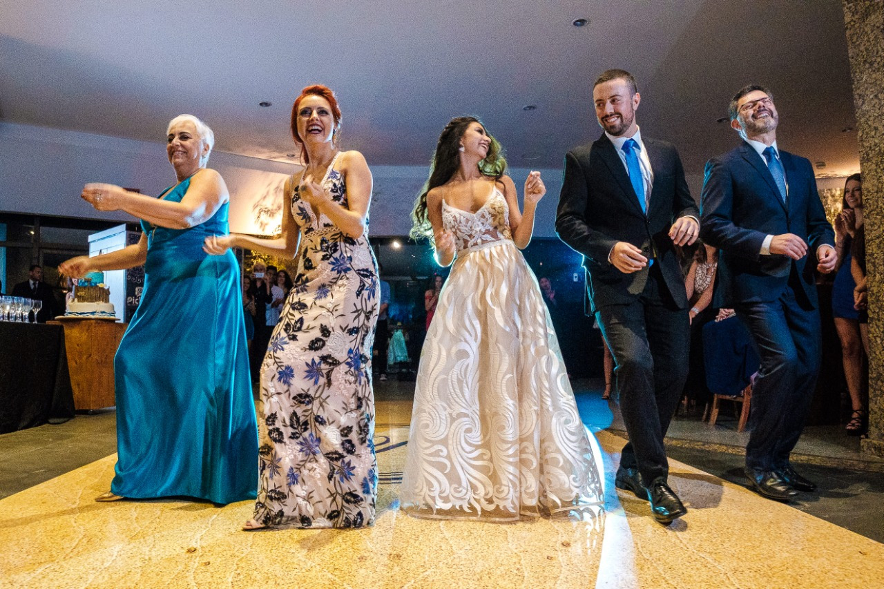 Casal de noivos felizes celebrando sua união em filmagem de casamento em Porto Alegre rodeados por amigos e família