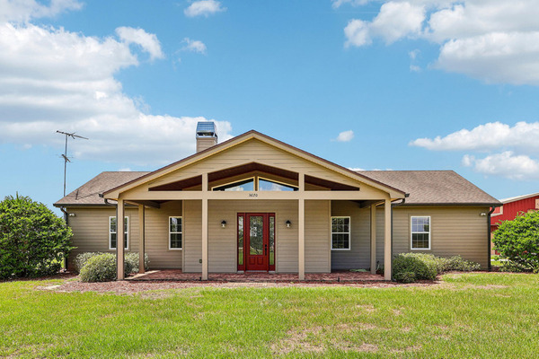 Front of the Haines City home with covered porch and red entry door.