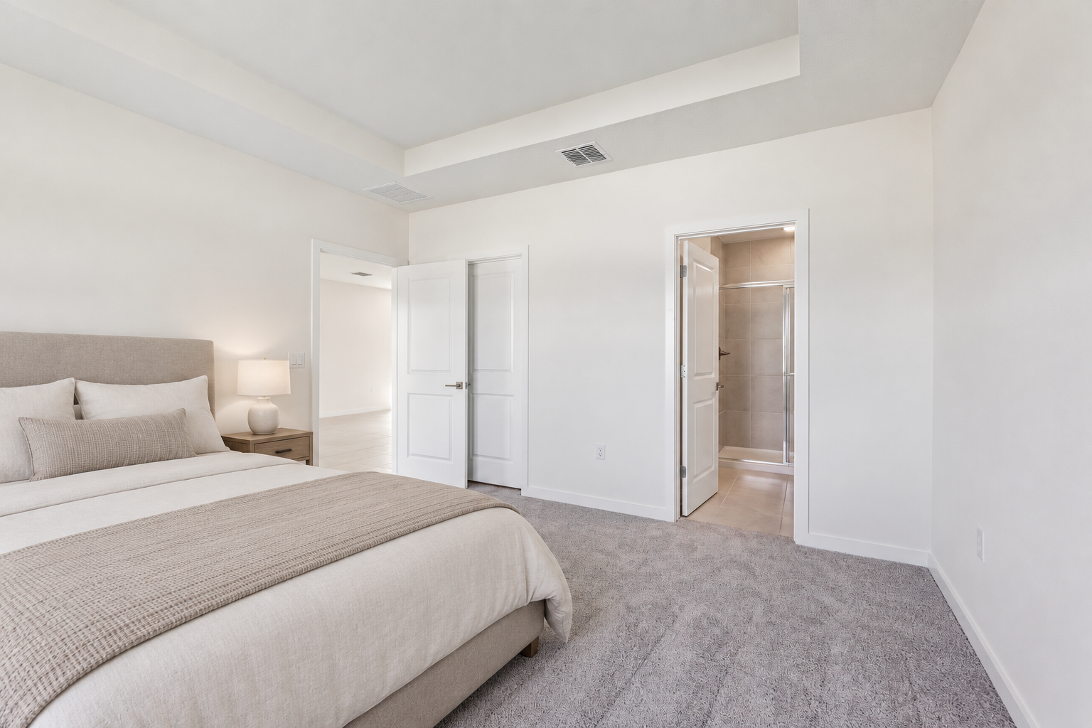 AI-assisted virtual staging concept of the same bedroom, with a neutral bed, bedside table and freestanding lamp added.