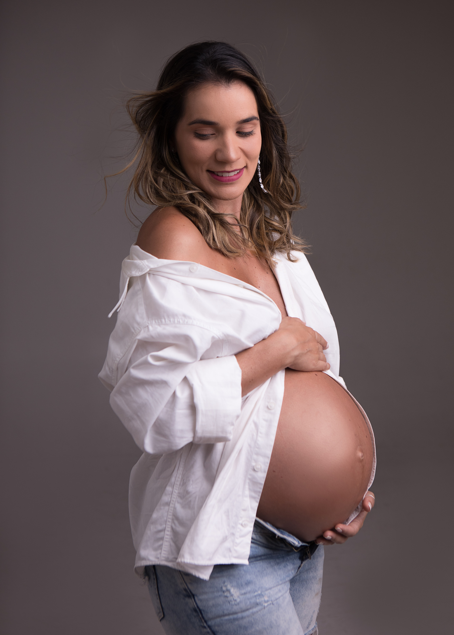 Fotos da gestante Djeni em estudio deitada na escada