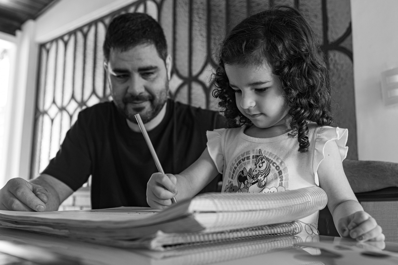 Fotografia de família: Pai e filha fazendo  o dever de casa juntos