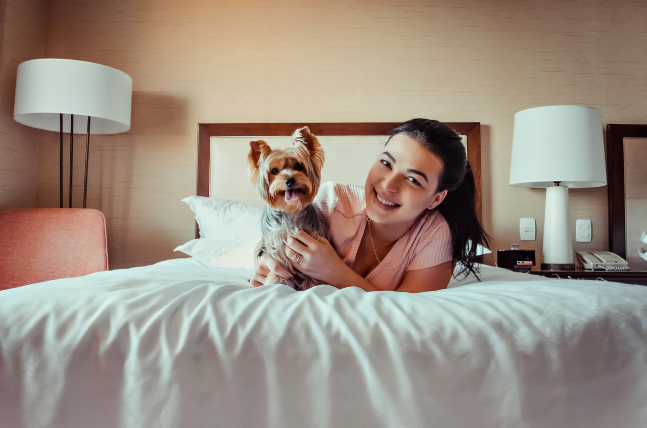 mulher com seus cachorro em suíte pet friendly do Hotel Sheraton