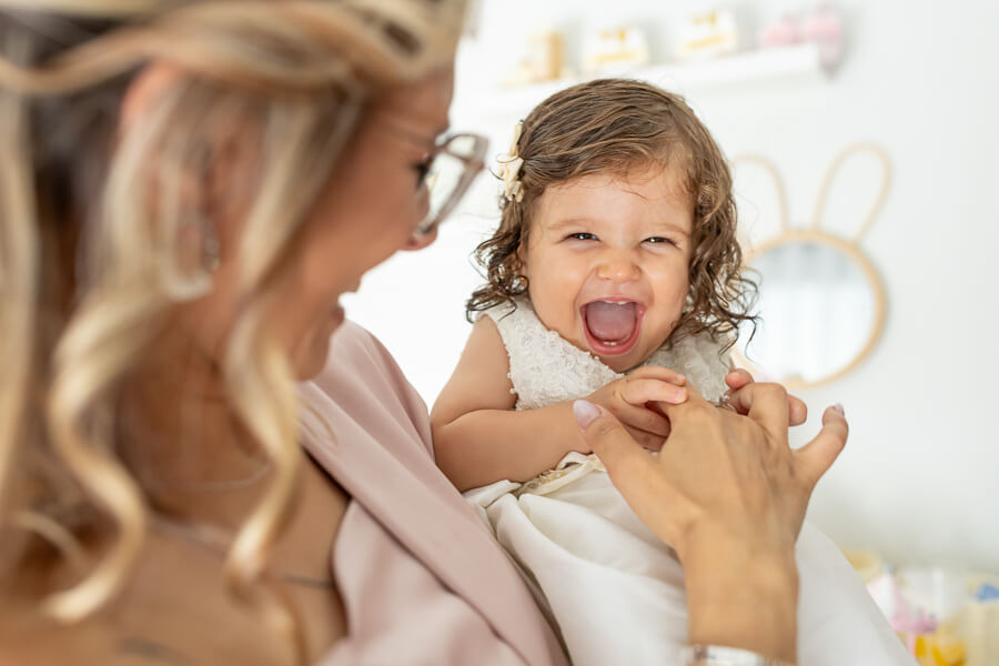 Mãe a brincar com a filha no dia do Batizado