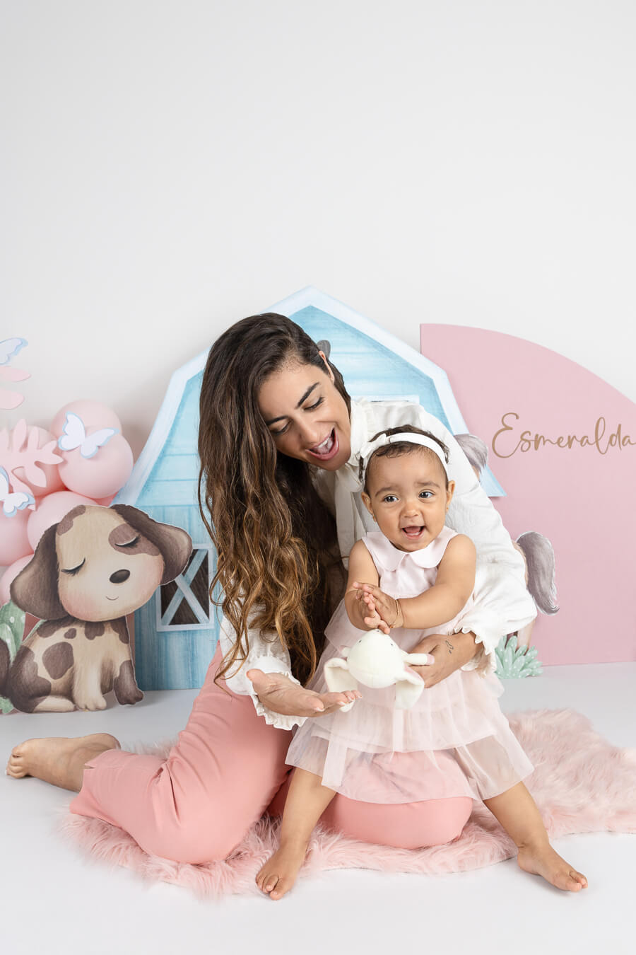 Mãe a brincar com a filha na sessão smash the cake