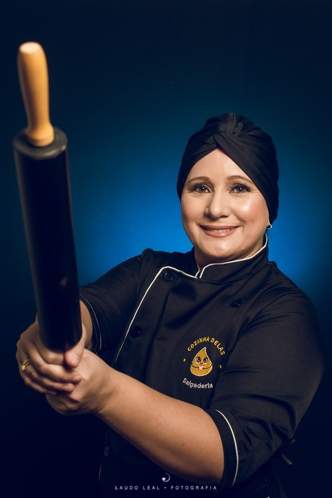 Mulher confeiteira segurando um rolo de massa- foto para empresa Cozinha Delasra demostrar