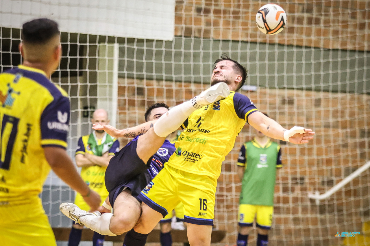 Jogo de futsal universitário fotografado em quadra