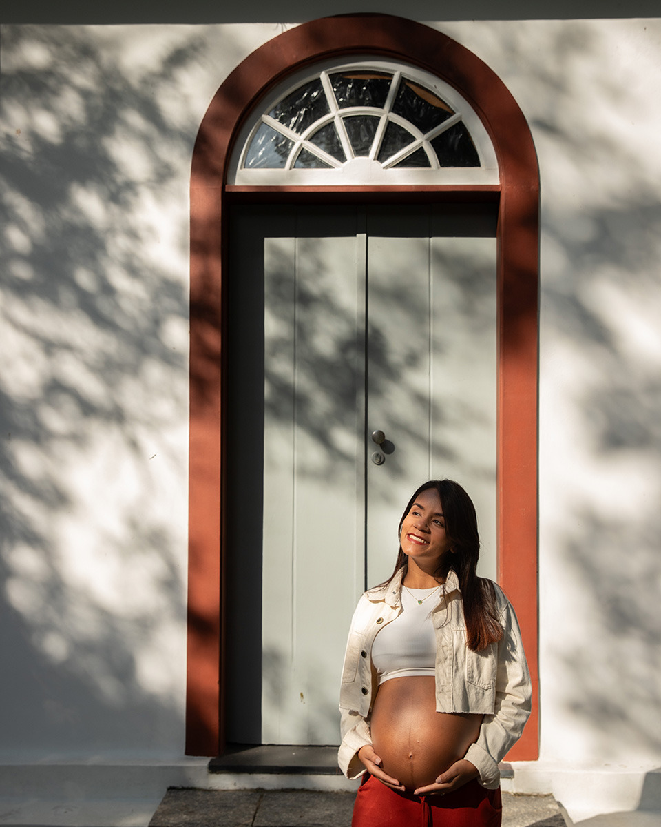 Gestante em frente a porta de construção charmosa com uma luz de final de tarde no Jardim Botânico do Rio de Janeiro