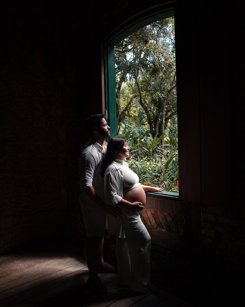 Casal de gestantes em frente a janela com luz especial no Jardim Botânico do Rio de Janeiro