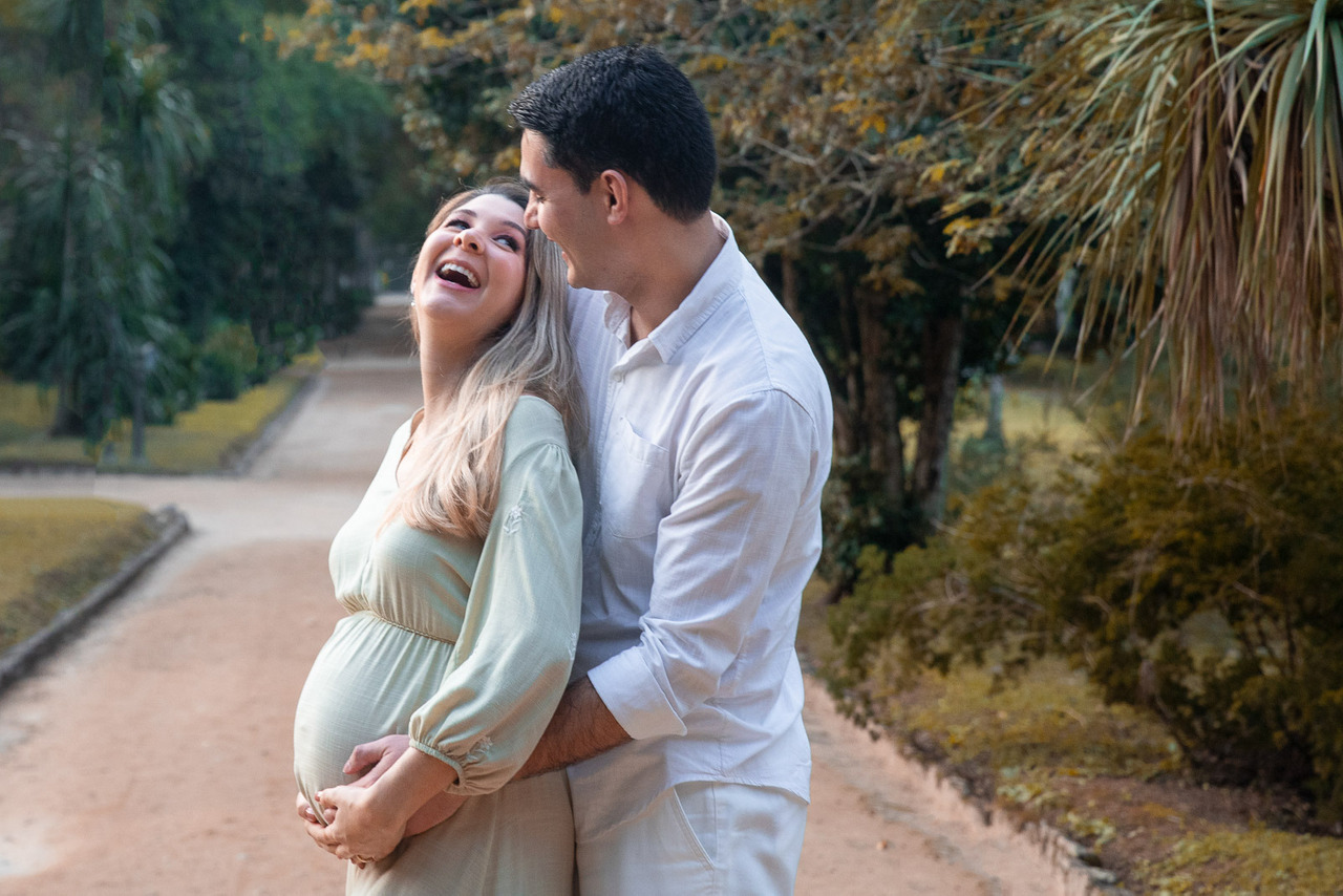 Casal sorrindo abraçados entre árvores do jardim Botânico do Rio de Janeiro