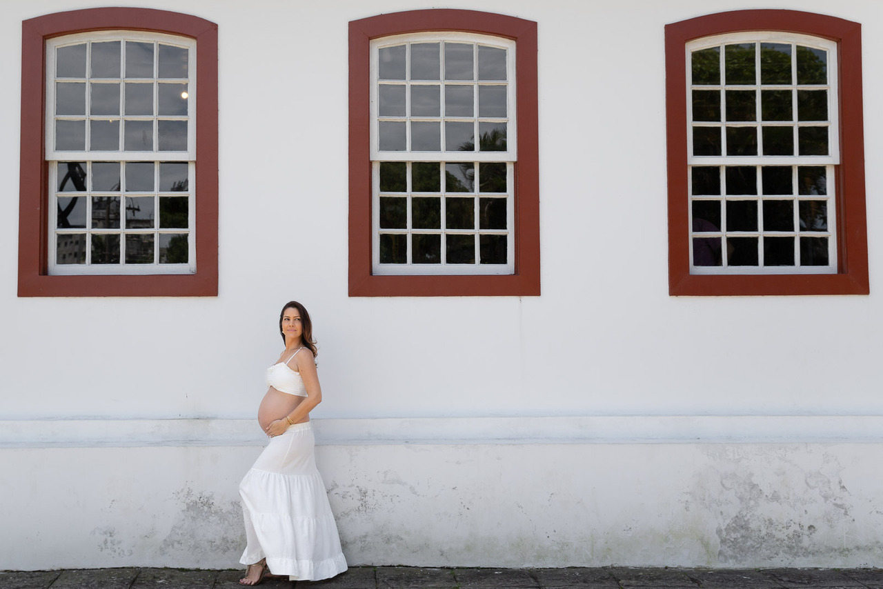 Gestante em frente a janelas de construção charmosa charmosas