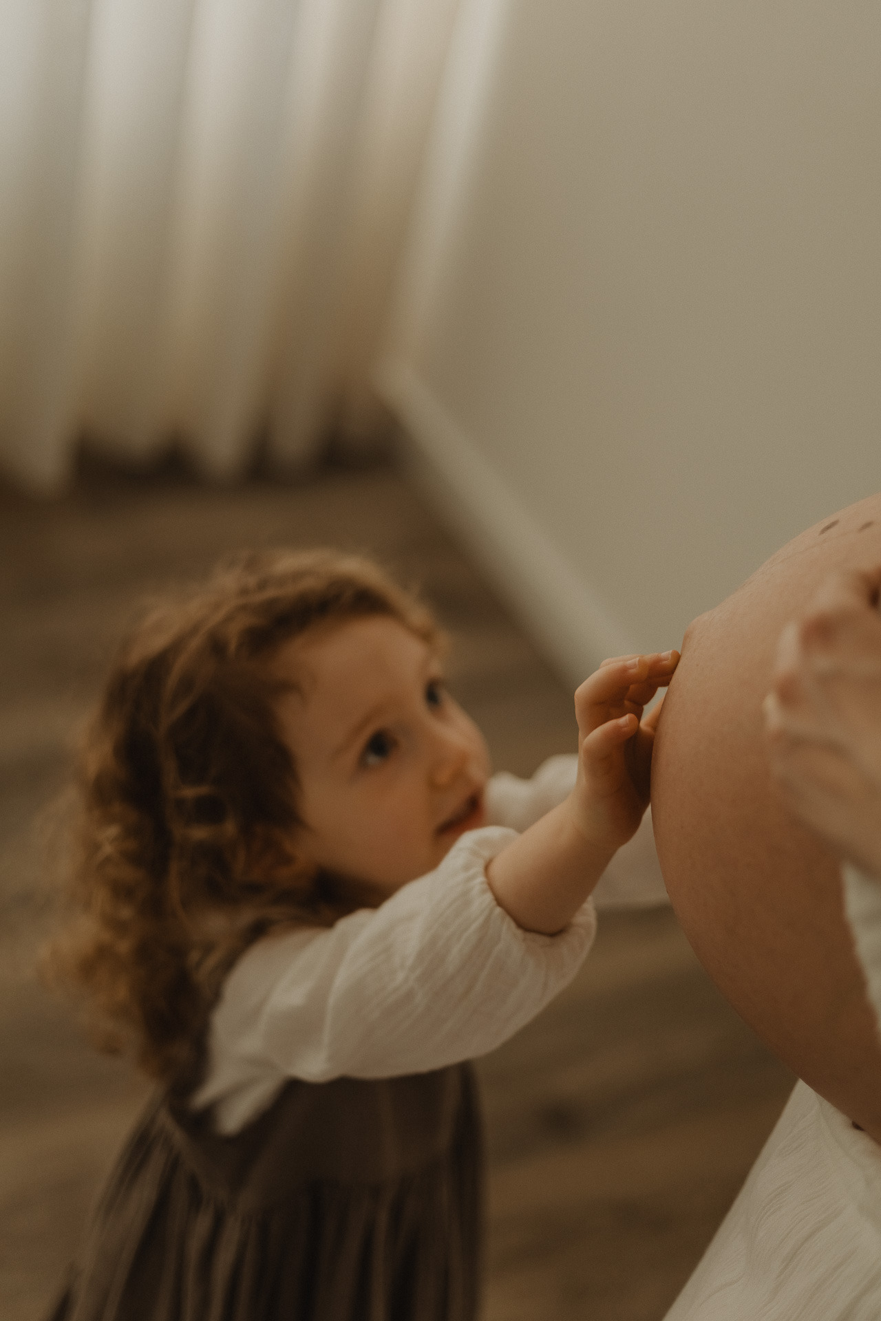 Sessão fotográfica de gravidez em Penafiel, com uma futura mãe a segurar a barriga num ambiente natural.
