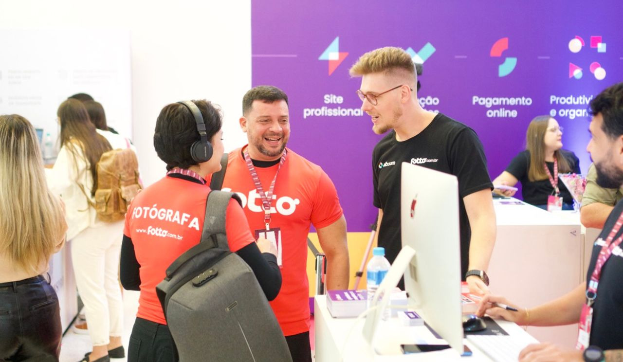 Marcelo Tesser, cofundador e CMO da Alboom e Fotto com clientes vestindo a camisa da Fotto no evento ExpoImage 2024