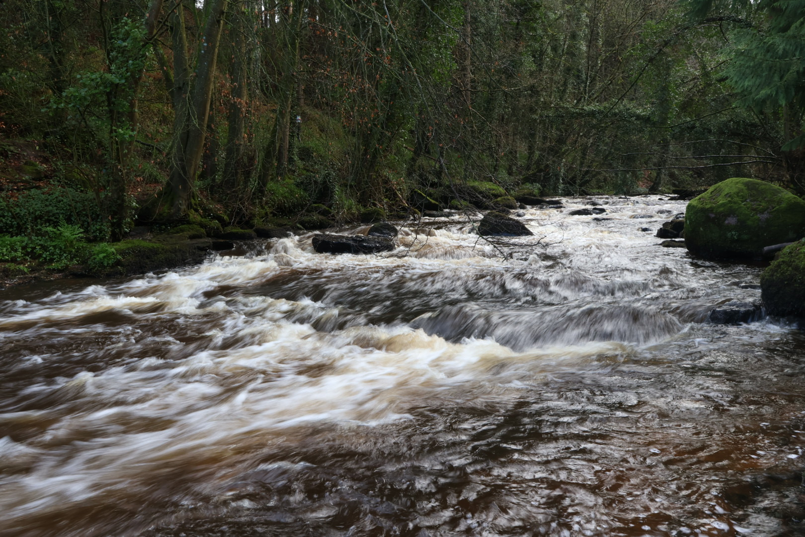 Fotografia de paisagem com longa exposição de um rio, mostrando o efeito seda na água e nitidez nas rochas, feita por ex-aluno do curso 'O Equilíbrio da Luz Ideal', demonstrando controle do obturador para criar movimento.