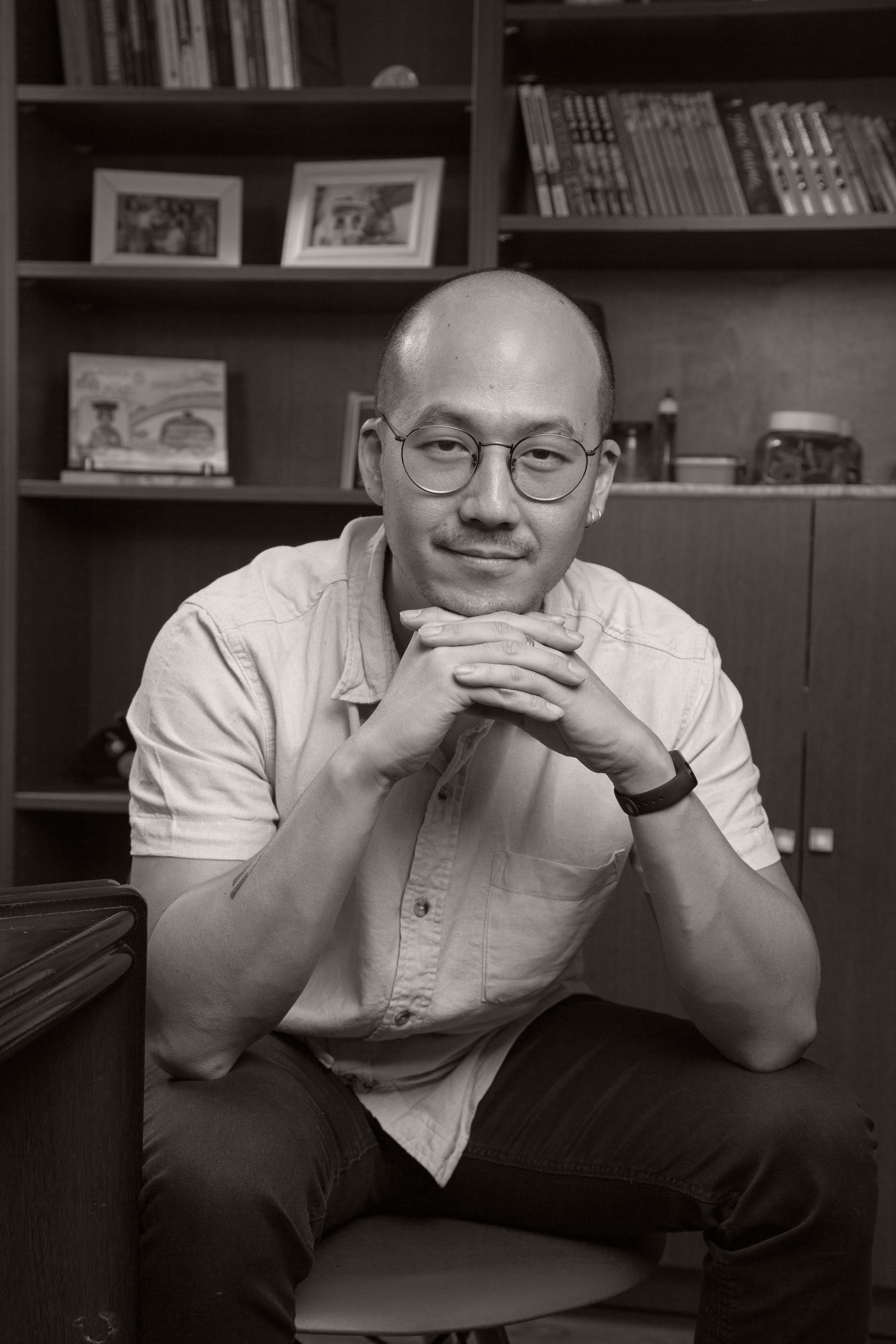 Retrato do fotógrafo Bruno Arita, olhando diretamente para a câmera, transmitindo profissionalismo e a paixão por registrar as histórias das famílias em foto preto & branco.