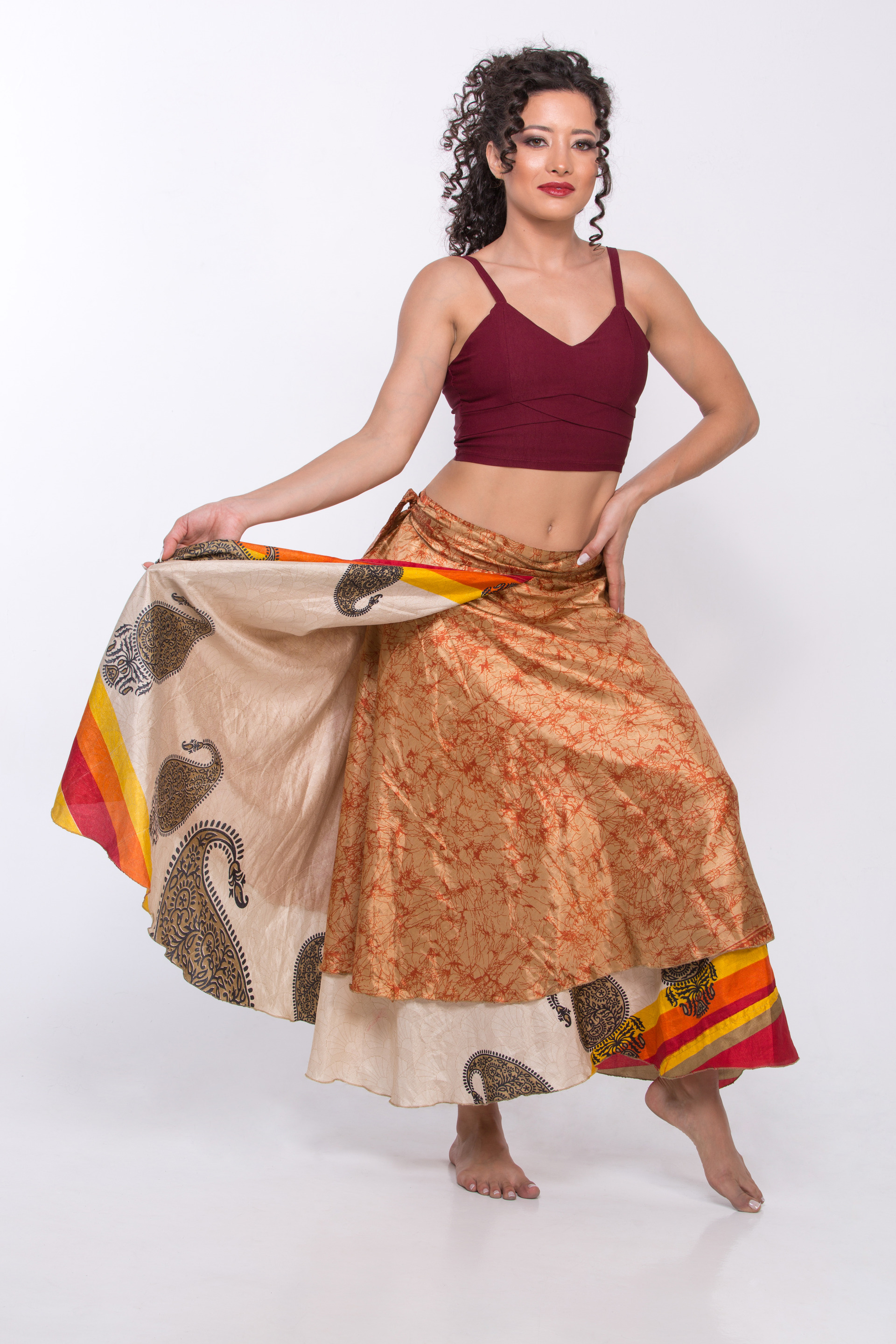 Retrato editorial de corpo inteiro de modelo feminina em pose elegante e leve, segurando delicadamente uma saia fluida, evocando um estilo de moda praia sofisticado.