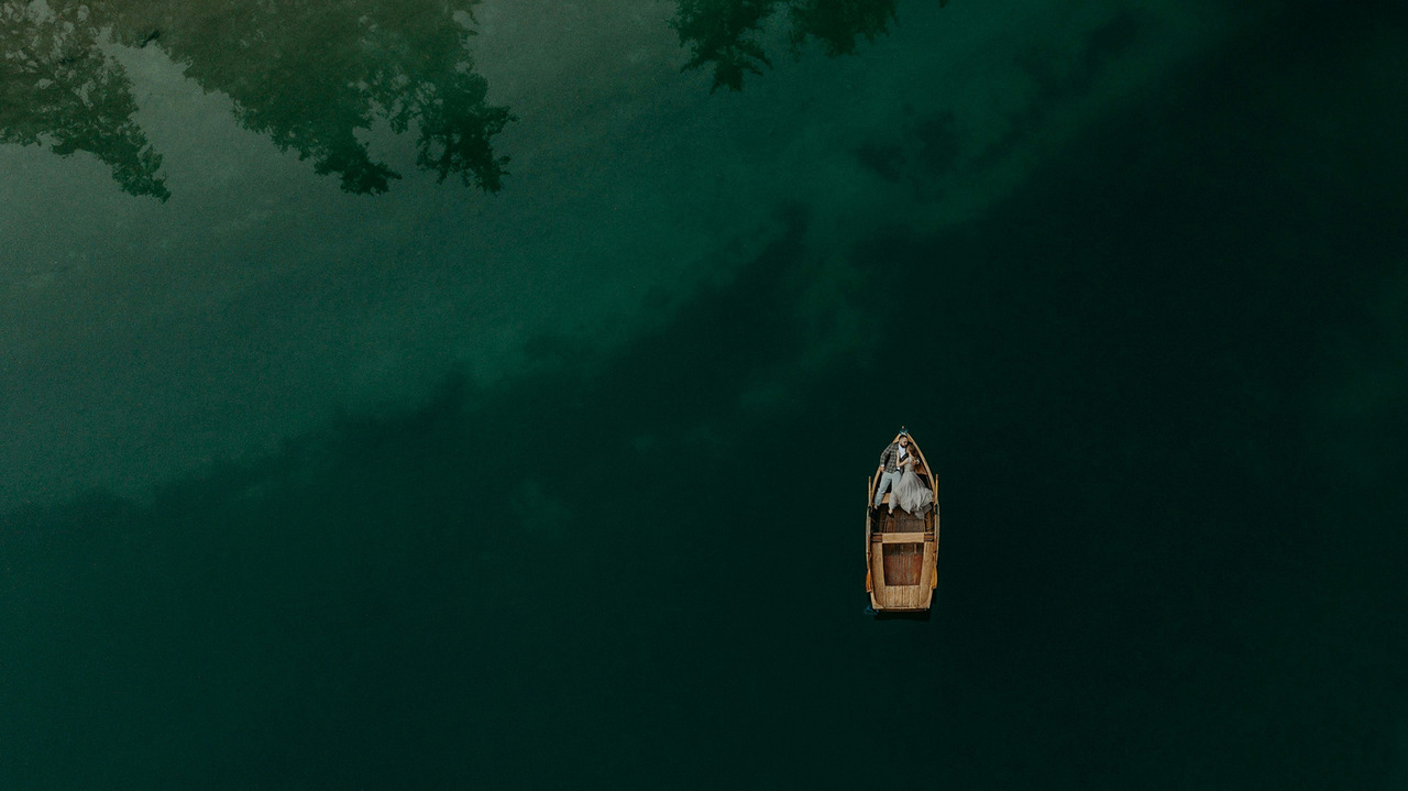 Casal no barco no Lago di Braies foto de drone
